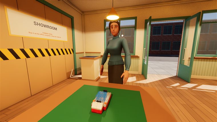 A shop worker behind the build table with a half-built tug boat